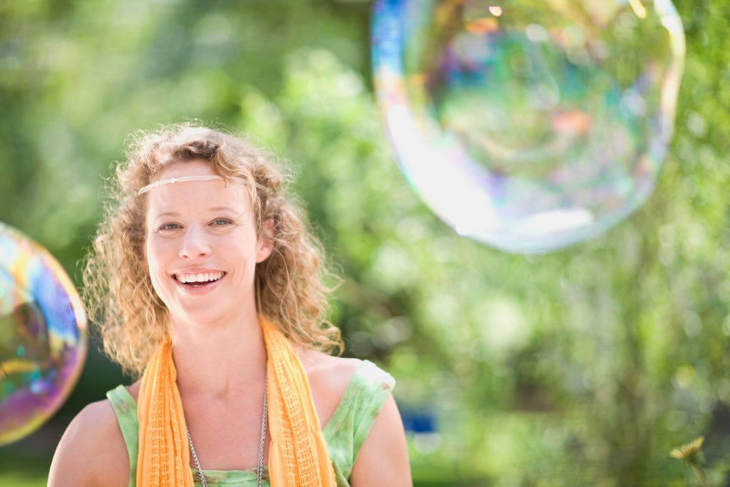 Young woman blowing bubbles outdoor.